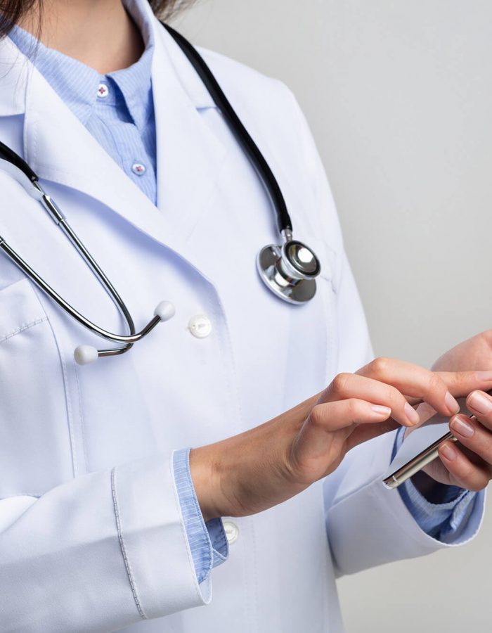 unrecognizable-doctor-using-smartphone-on-white-st-DLKHN8M unrecognizable-doctor-using-smartphone-on-white-st-DLKHN8M